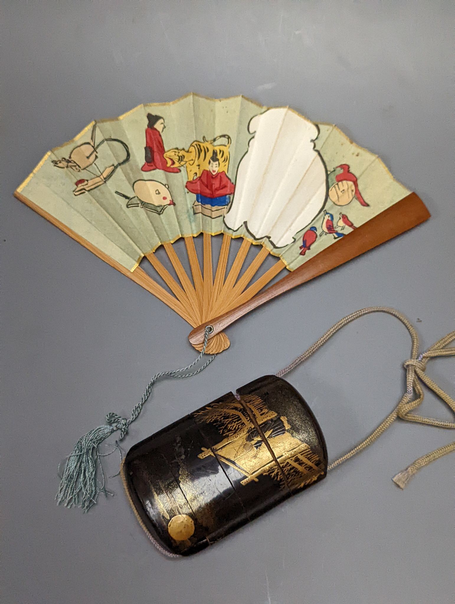 A 19th century Japanese lacquer three-case inro and a small Japanese woodblock printed fan with bamboo guards, 12cm